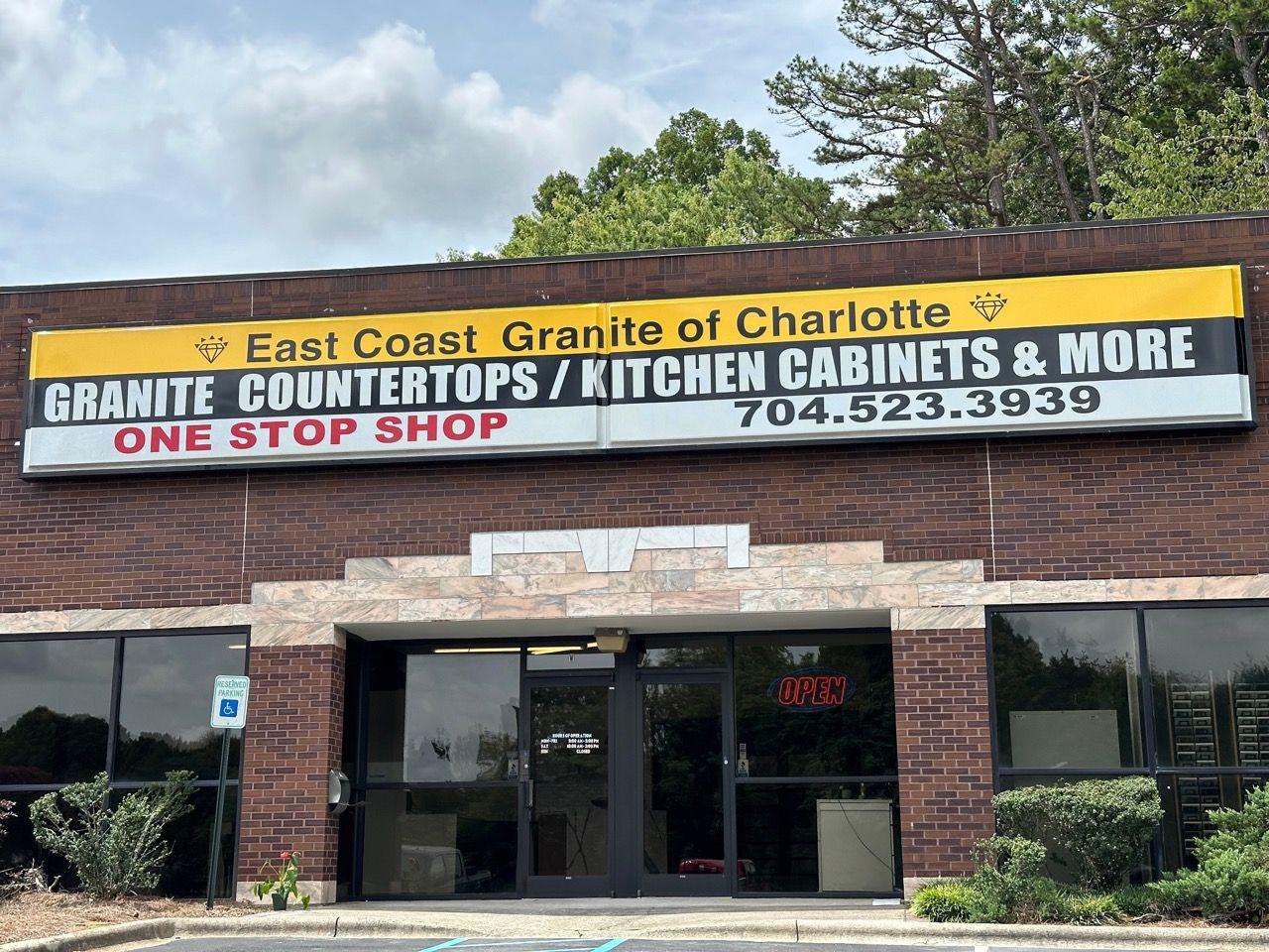 Exterior view of the East Coast Granite of Charlotte showroom on Clanton Road in Charlotte, featuring a bold storefront sign advertising granite countertops, kitchen cabinets, and more.